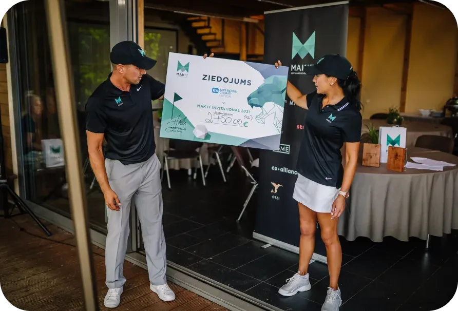 Two Mitigate colleagues holding an oversized donation cheque for SOS Bērnu ciemati at the MAK IT Invitational